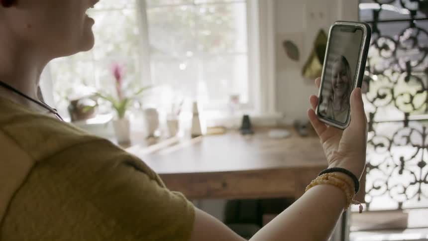 Two women video chat on a phone