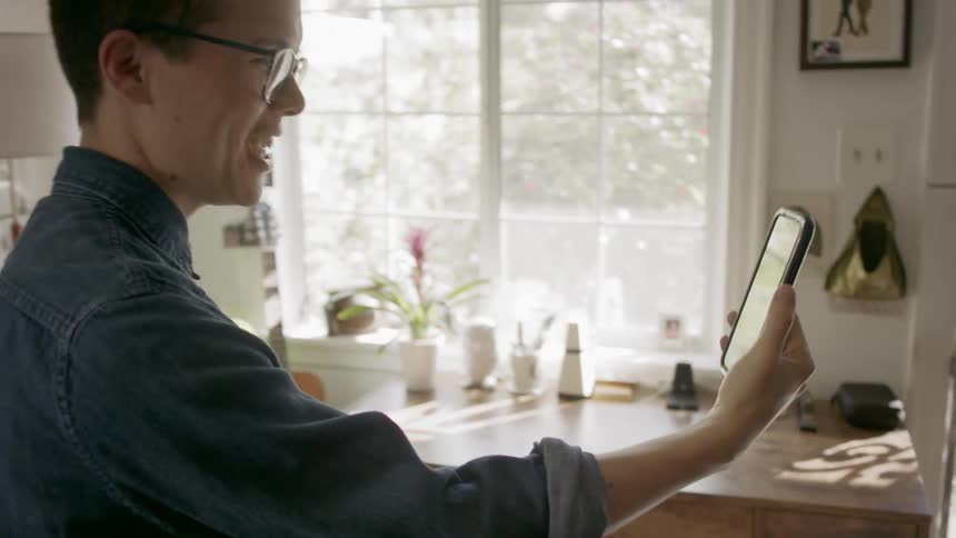 A man is talking with someone on the phone with video