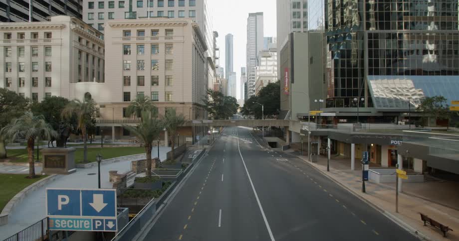 A large sign points the way to underground parking on an empty city street