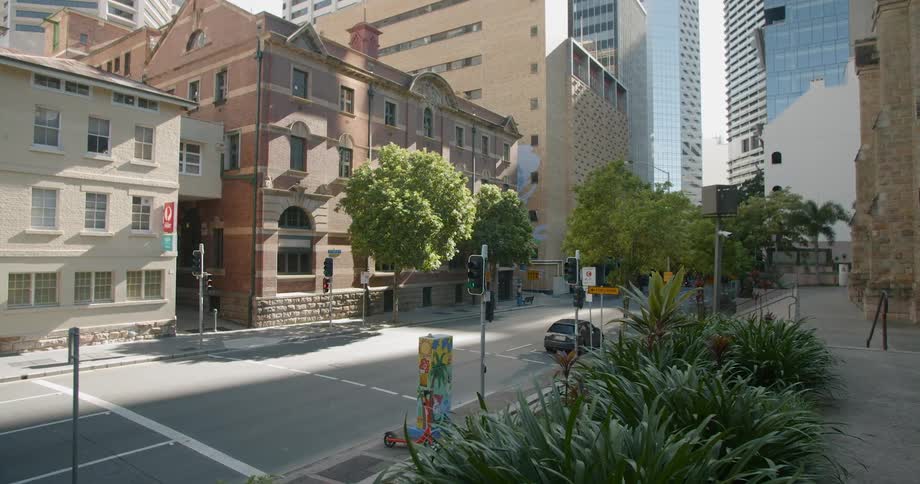 A wide street lined with tall buildings in a metropolis during the day