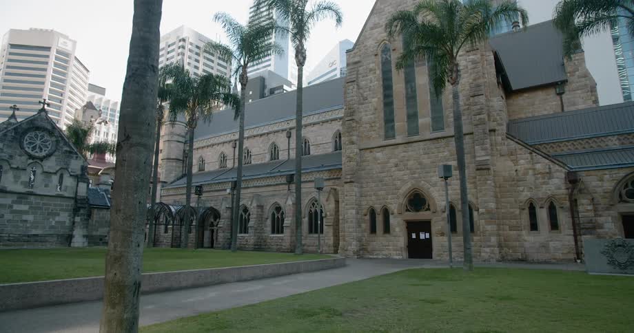 A view of a large stone cathedral in front of the tall buildings