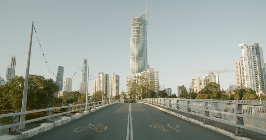 An empty bridge is displayed by a city skyline