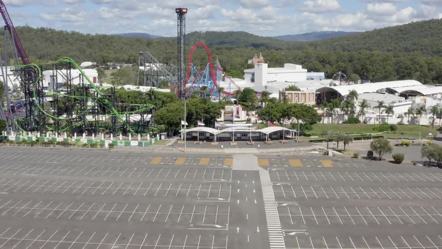 The empty parking lot and rides of a an amusement park on a sunny day