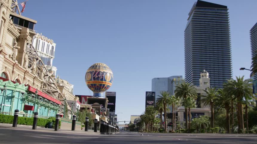 An empty las vegas palm tree lined street near the paris hotel on a sunny blue sky day