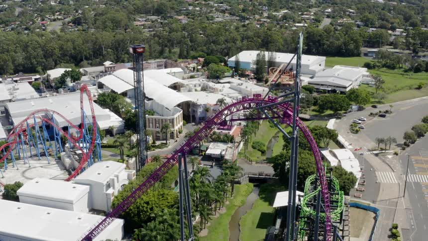 Roller coaster in amusement park near town at day