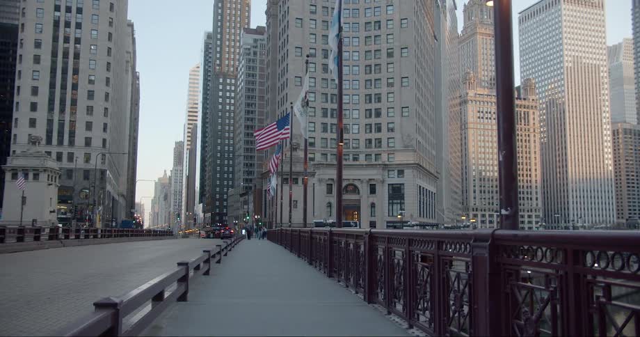 People walking across a bridge in a downtown area