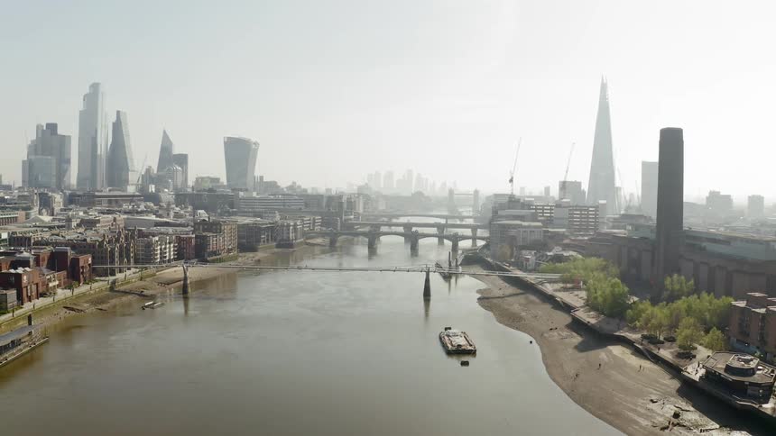 Series of bridges span the river between two sides of city on a foggy day