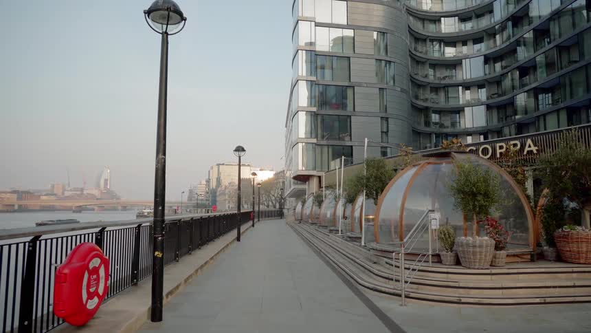 A waterside walkway next to a tall building in a city