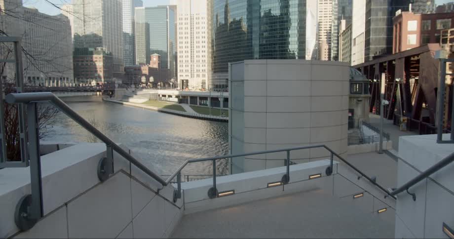 A staircase near a river with buildings in the background
