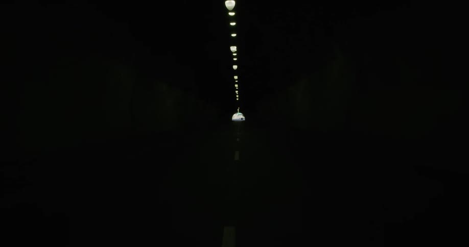 A tunnel with a road and lights
