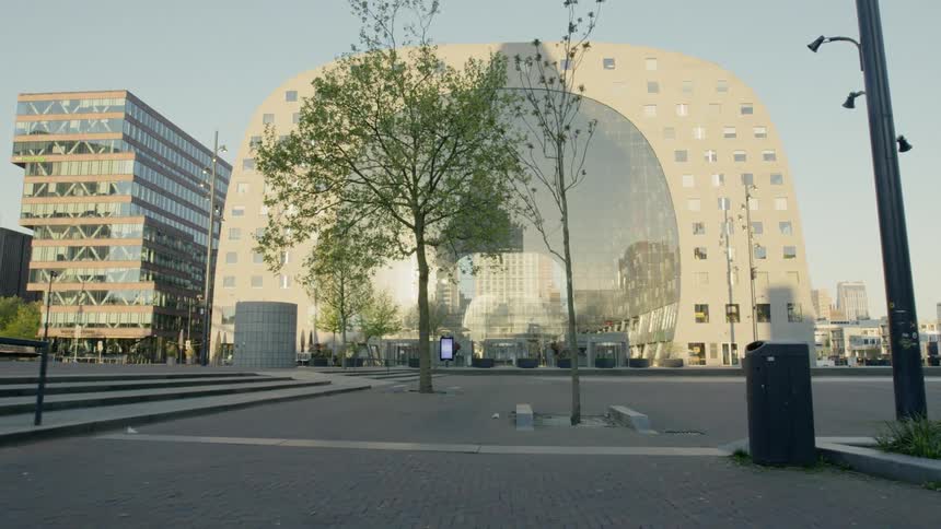 A public park near a large building shaped like a arch