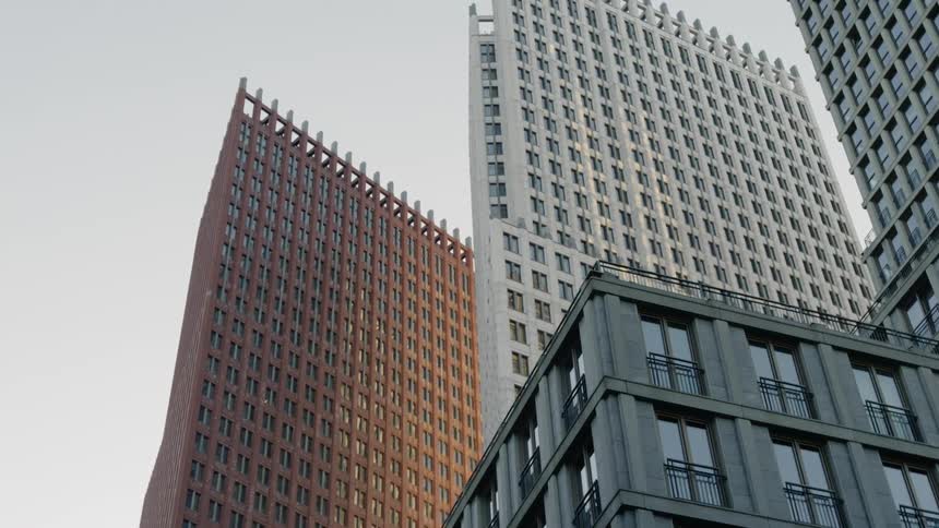 Skyscrapers stand above power lines against pale blue sky