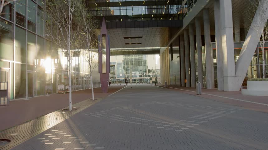 A wide sidewalk passes between large office buildings downtown