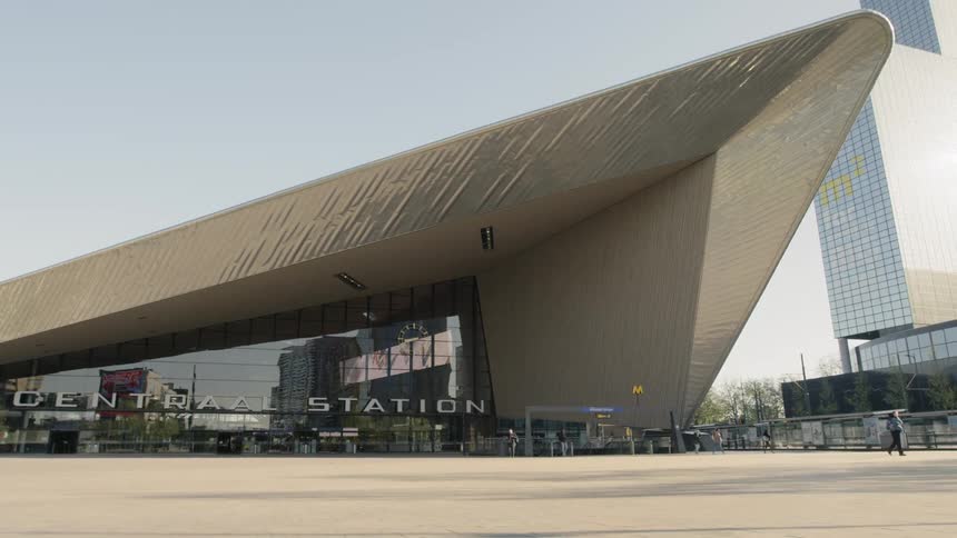 People are walking around a stadium in a city