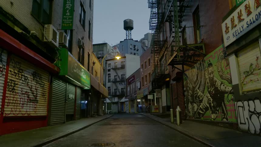 Businesses are closed and a street in empty in chinatown at night