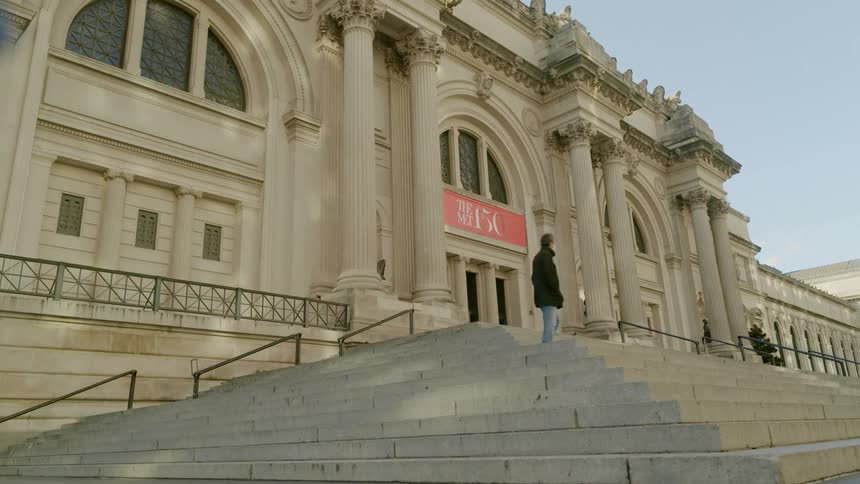 A building with stairs with people walking towards it