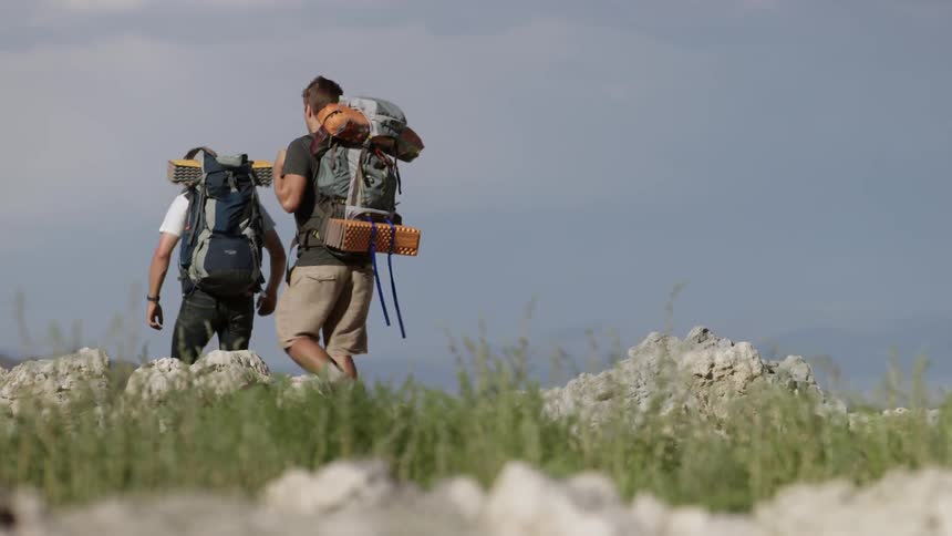 Hikers walk on a rocky area in the wilderness