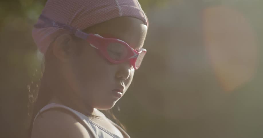 A child wears swim goggles and a cap