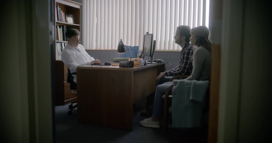 A doctor talks with a man and a woman