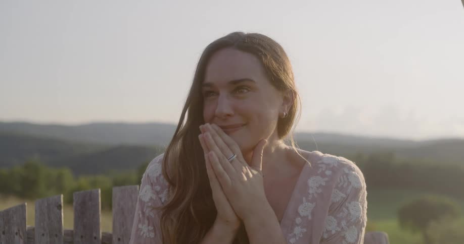 A woman smiles and nods her head while accepting a marriage proposal