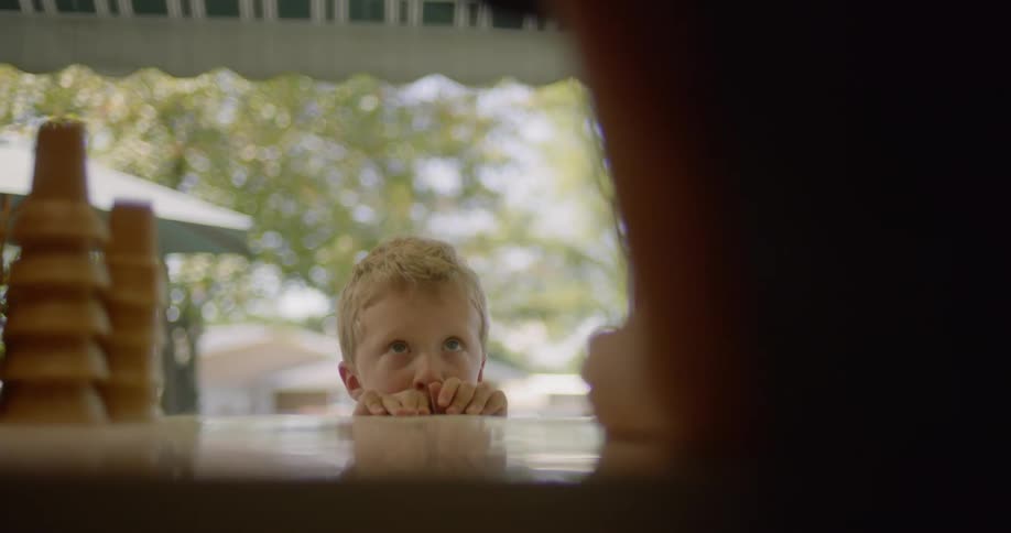 A boy looks up at a person in a store