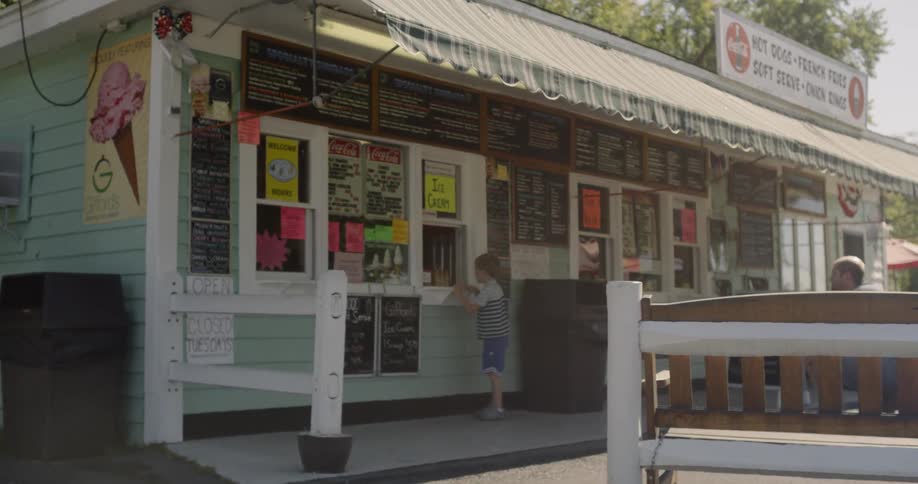 Child waits to collect an order in front of the kiosk