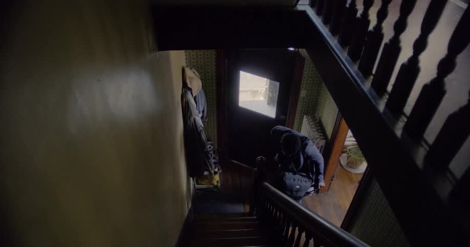 A man enters his home carrying a briefcase