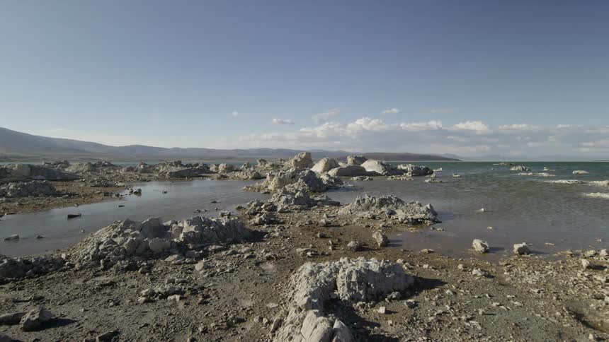A large rock filled area covered with water on a sunny day