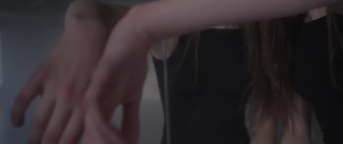 A woman rubbing her face on a mirror and then dancing