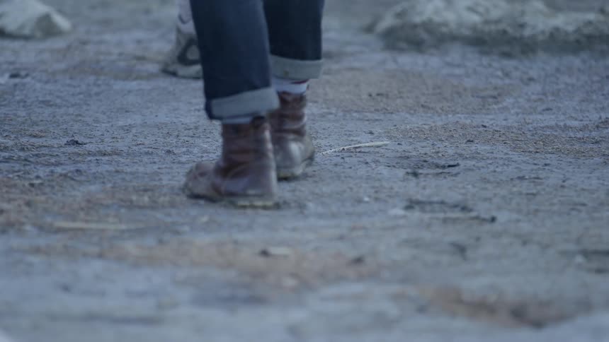 People are walking in the sand down a trail