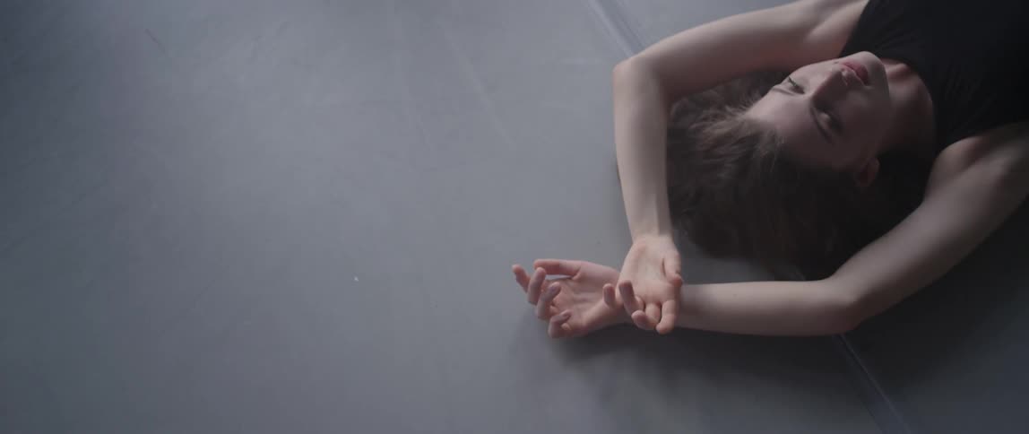 Woman laying on exercise mat stretches her arms over her head