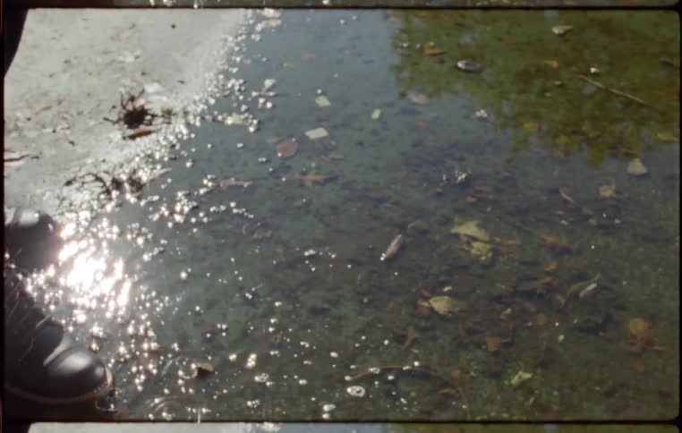 A woman kicks a puddle of water