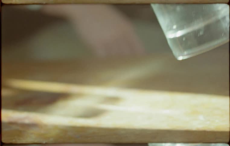 A man touches a glass of water on to a table