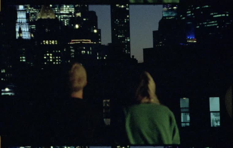 Young couple watches city skyline at night