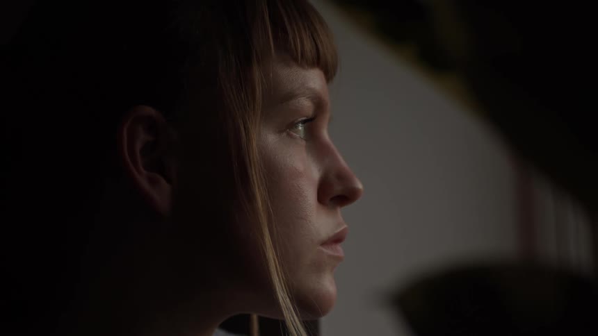 Close up of woman face looking out a window