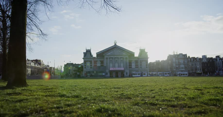 A grassy field with a trolley and a city in the foreground