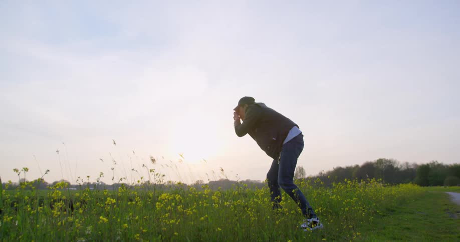 A person with a camera taking pictures on a grassy field
