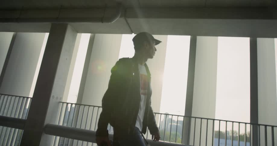 Man walks through building near balcony and rail