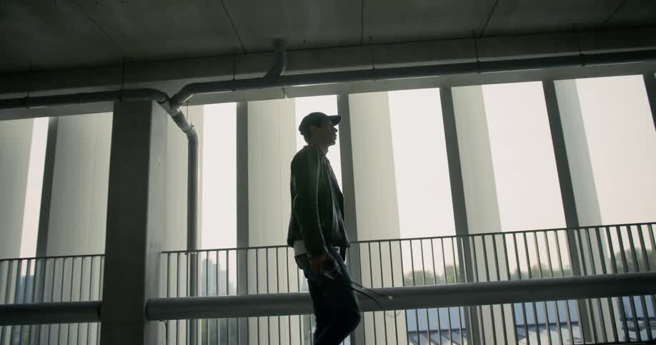 A man is walking through a buildings with windows