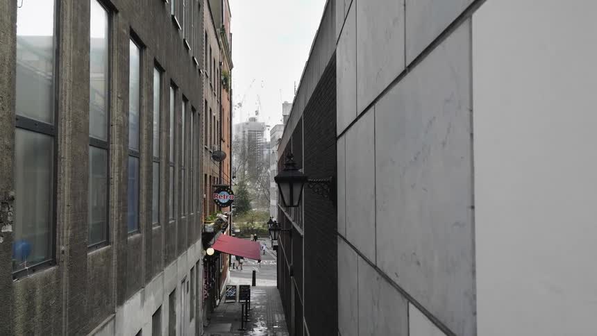 The red awning over the entrance of a business in the alley between two buildings in a city