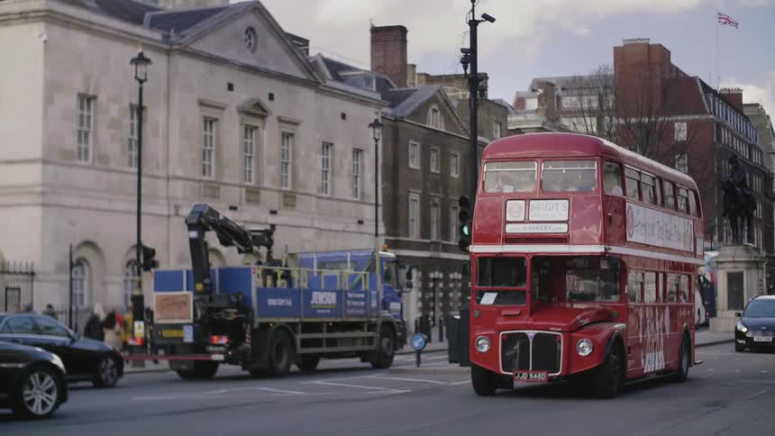 A mostly empty double decker tour bus travels on a city road