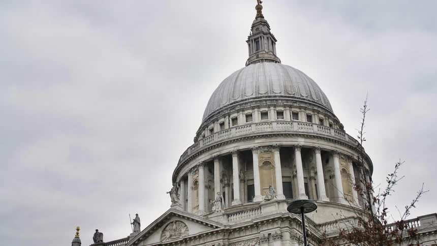 Statues decorated domed government building under a cloudy sky