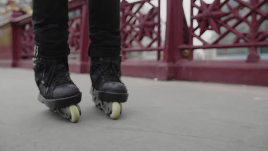 A person roller blades down a city sidewalk