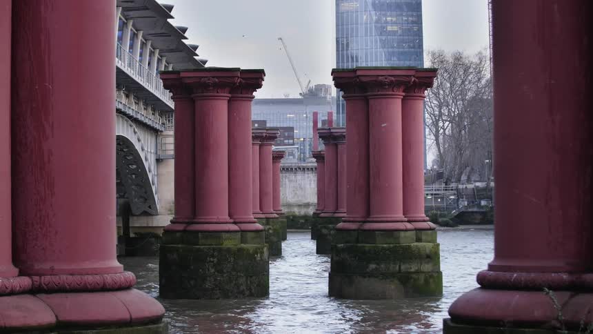 A river with red pillars next to a bridge