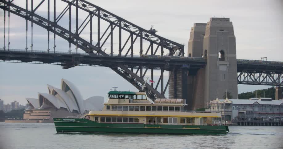 Ferry travels on the sea in front of the the sydney opera house