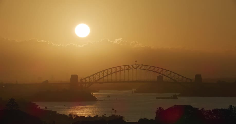 A bridge over a river with the sun in the background