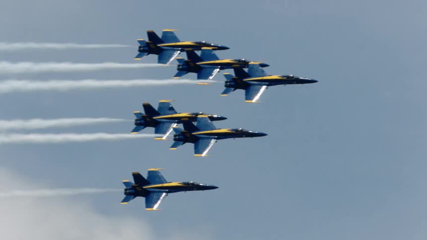 Several blue jets fly alongside each other in the sky