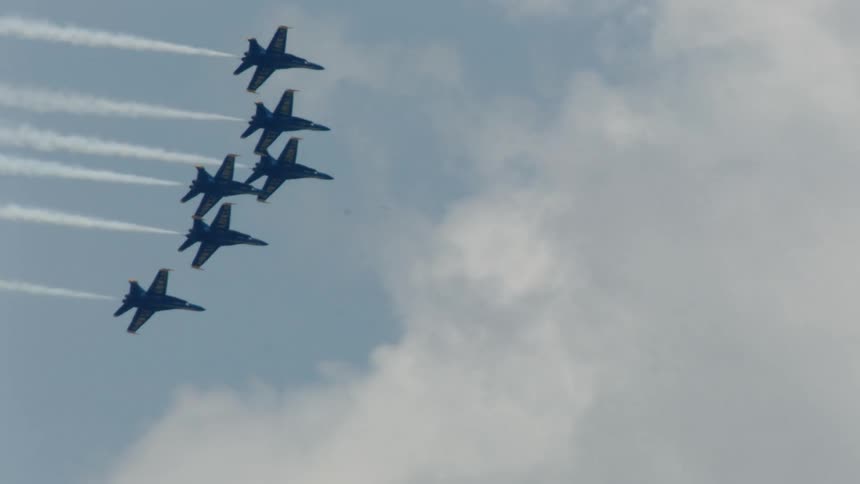 Military planes flying in formation over high rise buildings