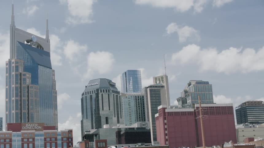 Planes fly in formation behind skyscrapers in a city