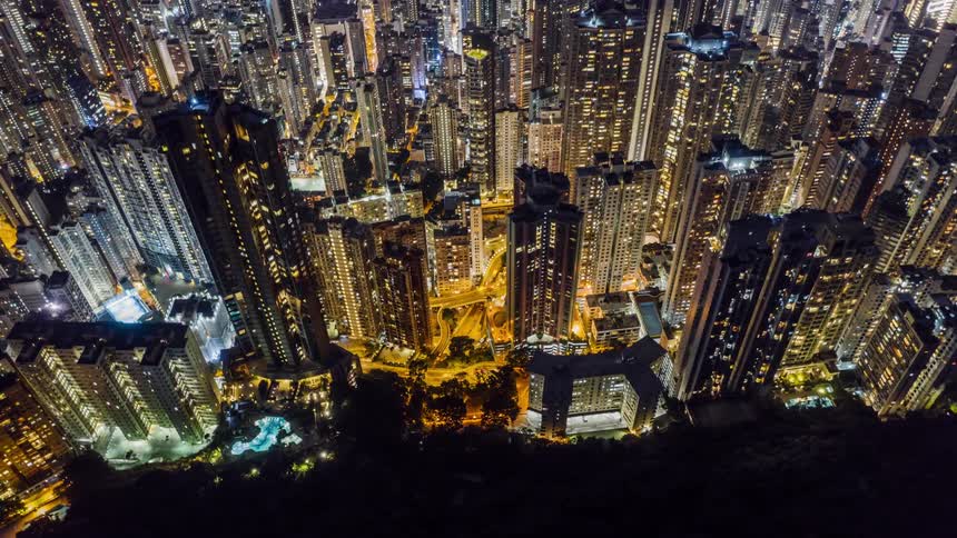 A city from the air at night with time lapse transportation on the roads below the buildings